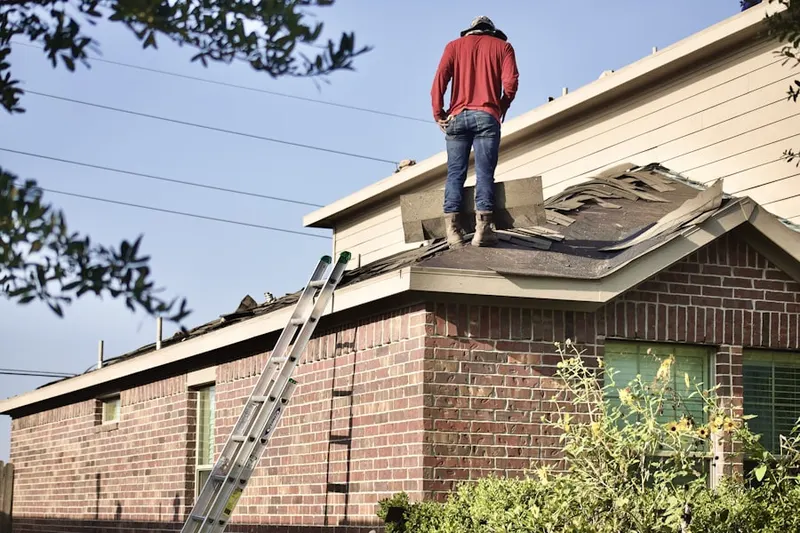 Professional roofer working on a residential roof in Mantua Grove